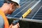 Male worker with solar batteries. Man in a protective helmet. Installing stand-alone solar panel system