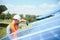 Male worker with solar batteries. Man in a protective helmet. Installing stand-alone solar panel system