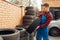 Male worker at the stack of tyres, tire service