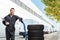 Male worker standing with tires on a hand truck outside a warehouse