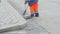 A male worker sweeps and cleans the street