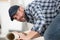 Male worker unrolling carpet on floor at home