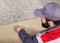 Male Worker Unrolling Carpet On Floor At Home, view from above