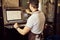 Male worker using control panel of coffee roasting machine