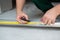 Male worker works with profile for drywall, marker marks for cutting. Construction work, repair.