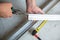 Male worker works with profile for drywall, marker marks for cutting. Construction work, repair.