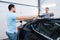 Male workers holds sheet of car tinting, tuning