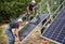 Male workers installing photovoltaic solar panels outdoors.