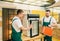 Male workers in uniform repair refrigerator