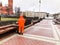 Male working cleaner in orange overalls wearing robe clothes working cleans the streets of the city