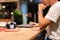 Male working on laptop at night  in coffee shop with camera on table.