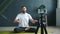 Male yoga teacher recording tutorial using smartphone camera in modern studio