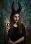Maleficent demonic. young pretty dressed as a fairy with horns and magic ball