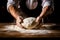 Males hands kneading dough on wooden table. Close up