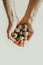 Males thin hands hold many small spotted quail eggs. minimalism Easter greeting card. selective focus