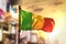 Mali Flag Against City Blurred Background At Sunrise Backlight