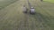 Malle, Belgium, 18-09-2021, Aerial of tractor baler making straw bales in field after wheat harvest in summer on farm