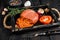 Mallorcan Sobrassada cured pork meat sausage in a wooden tray. Black wooden background. Top view