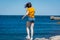 MalmÃ¶, Sweden - June 14, 2020: A young girl balance on a stone, looking at the blue, cold waters of  Oresund. Going to the beach