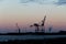 MalmÃ¶, Sweden - November 25, 2018: A big crane stands alone in the winter sunset in the Copenhagen MalmÃ¶ Port in the industrial