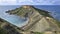 Malta island, near of golden bay, sea coast erosion, grey gravel. Gravel and green bush cliff hills. Peninsula in blue sea bay