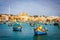 Malta - marsaxlockk port filled with typical boats called luzzu