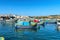 Malta, Marsaxlokk, August 2020. Traditional fishing boats on the blue water of the bay.