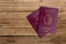 Malta passport, carried by a Maltese citizen, two passports on a wooden floor