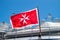 Maltese old flag on pole on ferry`s stern. Ongoing cruise to islands. Blue sky background, close up view