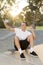 Man 30s sitting on skate board after sport boarding training session taking selfie photograph portrait or picture on mobile phone