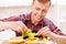 Man adding lettuce leaves to his sandwich