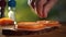 Man is adding some salt on the sandwich, close-up slow motion video