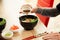 A man adds soy sauce to Poke salad. A man's hand pours soy sauce into a bowl of salad. Guy young man dressing salad with