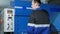 Man adjusts operation of the machine for cutting sheet metal on a large hydraulic guillotine shears. Ironing presses the