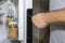 A man adjusts the refrigerator door with a screwdriver