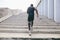 Man african running up flight of stairs, training outdoor while jogging up steps