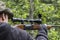 A man aiming through a scope on a hunting rifle