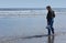 Man alone on the beach, wading in the little waves