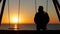 Man alone swinging looking at empty seat