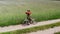 man alone walking by country road in a green field, holding suitcase in a hand, funny travel concept, retro style