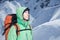 Man alpinist looks up against a winter mountain landscape.