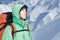 Man alpinist looks up against a winter mountain landscape.