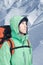 Man alpinist looks up against a winter mountain landscape.