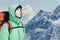 Man alpinist looks up against a winter mountain landscape.