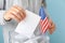 Man american flag putting ballot into voting box against blue background