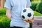 man with amputated arm holds foot on soccer ball while standing on the lawn