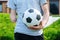 man with amputated arm holds foot on soccer ball while standing on the lawn