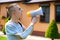 Man with amputated arm and prosthesis talking on the phone sitting on the lawn