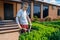 Man with an amputated arm and a prosthesis is trimming bushes in a garden