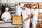 Man Analyzing Breads While Colleagues Working In Bakery